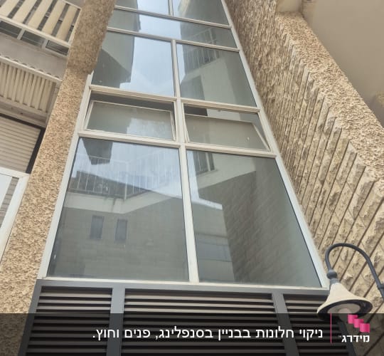 חזית בניין עם חלונות זכוכית ולבנים